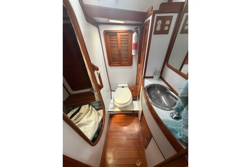 Slide: The Image of 1989 Tayana Vancouver 42 yacht bathroom with wooden accents, sink, and toilet. - 29