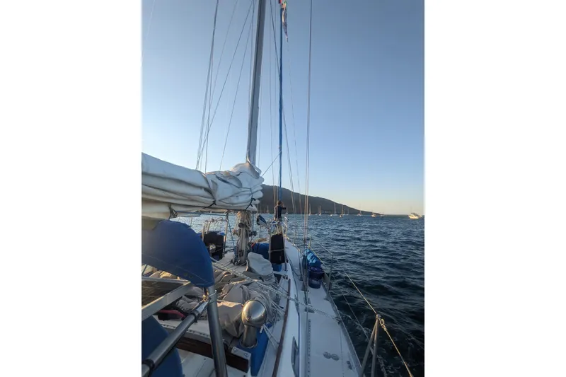 Slide: The Image of 1989 Tayana Vancouver 42 sailboat on calm waters at sunset, with distant hills. - 35