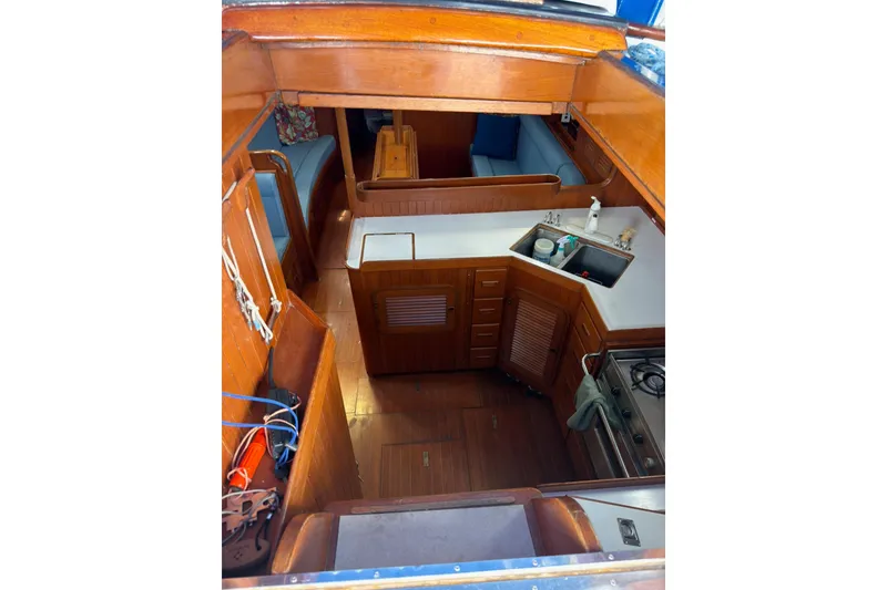 Slide: The Image of Interior of 1989 Tayana Vancouver 42 sailboat with wooden cabinetry and compact kitchen area. - 21