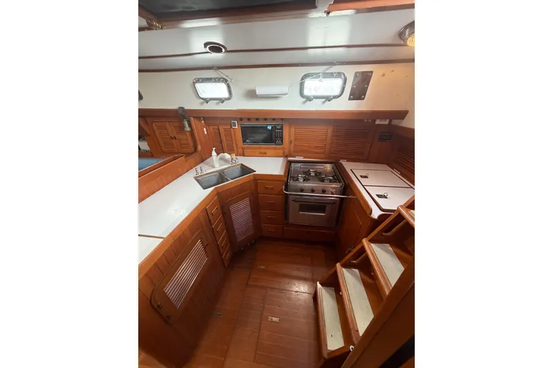 Slide: The Image of Cozy galley kitchen in 1989 Tayana Vancouver 42 sailboat with wood cabinetry and stainless steel appliances. - 22