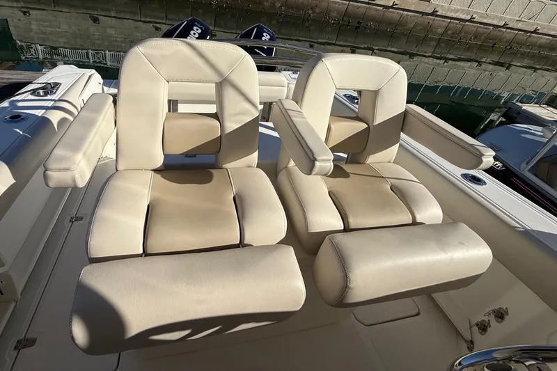 Slide: The Image of 2025 Boston Whaler 250 Outrage boat seats with beige upholstery and armrests. - 31