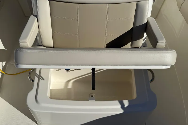 Slide: The Image of 2025 Boston Whaler 250 Outrage seat with storage compartment, featuring beige upholstery. - 38