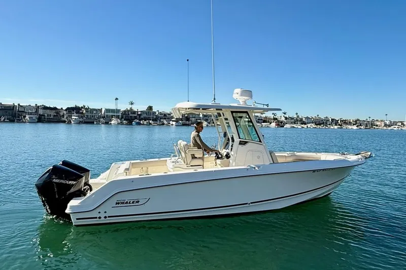 The Image of 2025 Boston Whaler 250 Outrage boat on calm water, clear sky background. - 0