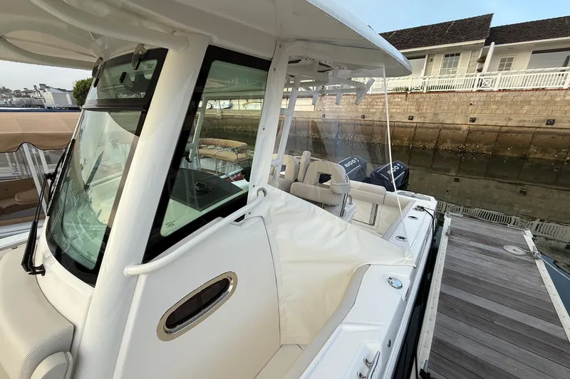 Slide: The Image of 2025 Boston Whaler 250 Outrage docked, showcasing sleek design and spacious interior. - 12