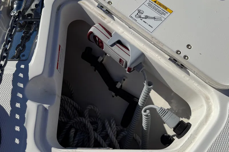 Slide: The Image of Anchor storage compartment on 2025 Boston Whaler 250 Outrage boat, featuring ropes and equipment. - 45