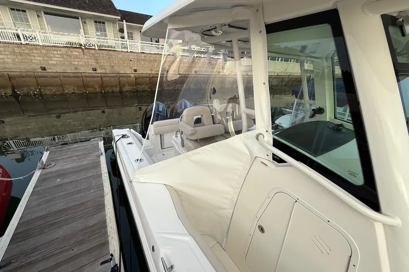 Slide: The Image of 2025 Boston Whaler 250 Outrage docked, showcasing sleek design and spacious seating. - 11
