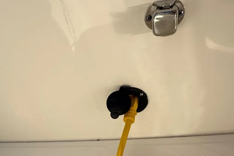Slide: The Image of Power outlet on 2025 Boston Whaler 250 Outrage with yellow cable connected. - 36
