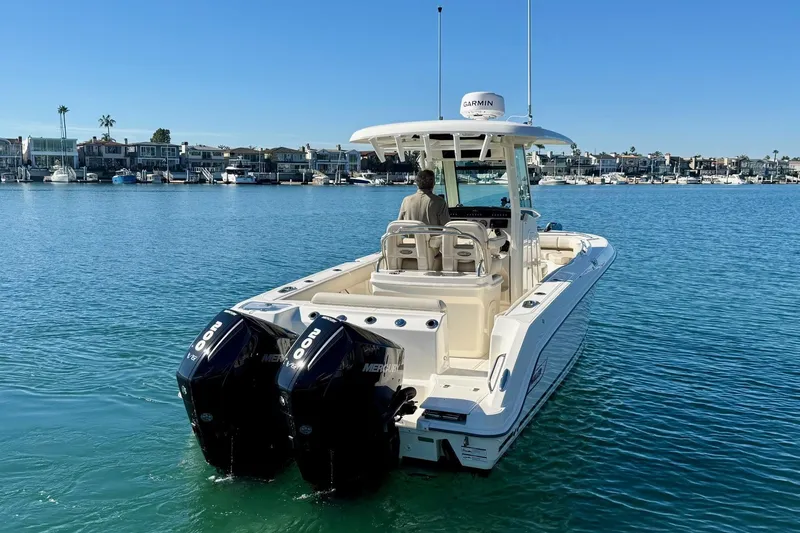 Slide: The Image of 2025 Boston Whaler 250 Outrage boat with dual Mercury engines on calm water. - 3