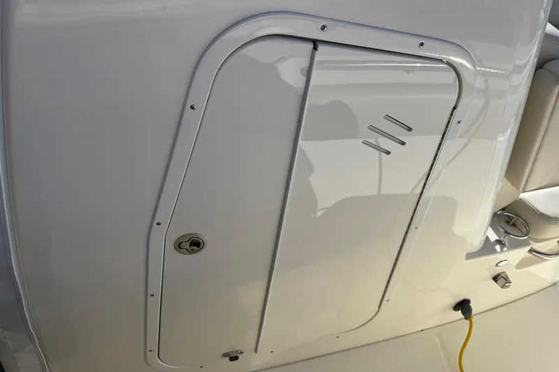 Slide: The Image of 2025 Boston Whaler 250 Outrage boat interior, featuring a sleek storage compartment door. - 34