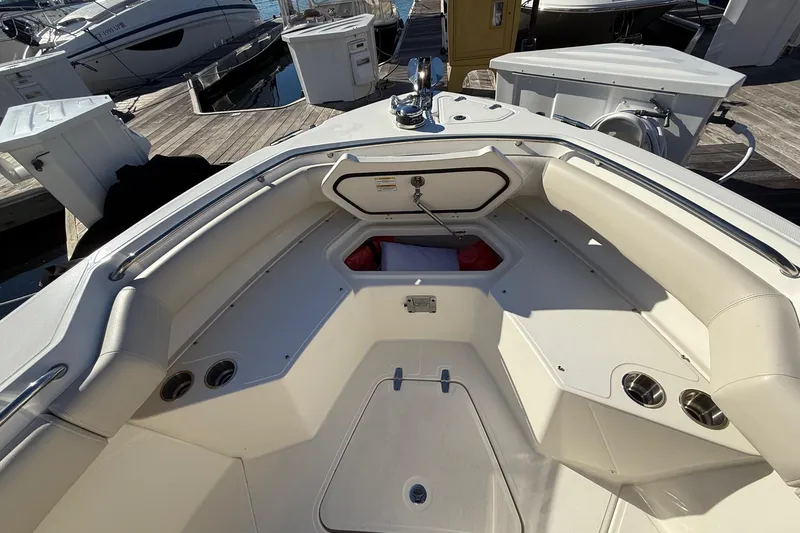 Slide: The Image of 2025 Boston Whaler 250 Outrage boat interior with seating and storage at dock. - 41