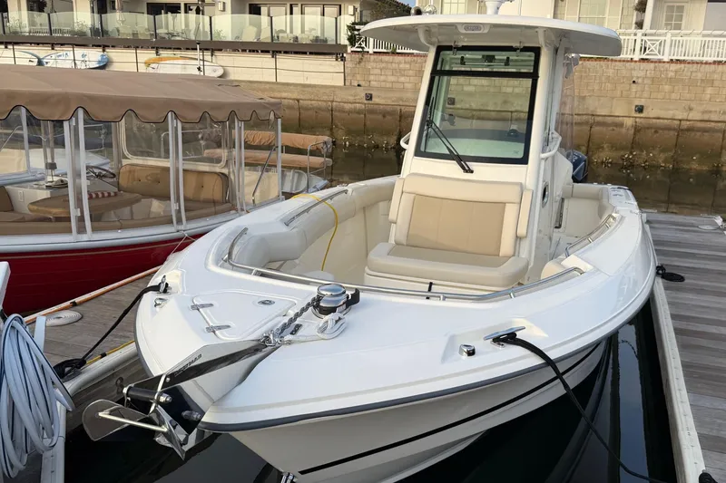 Slide: The Image of 2025 Boston Whaler 250 Outrage docked, showcasing sleek design and spacious seating. - 9