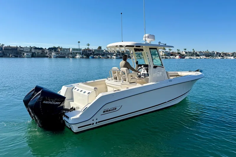 Slide: The Image of 2025 Boston Whaler 250 Outrage boat on calm water, featuring Mercury engines. - 2