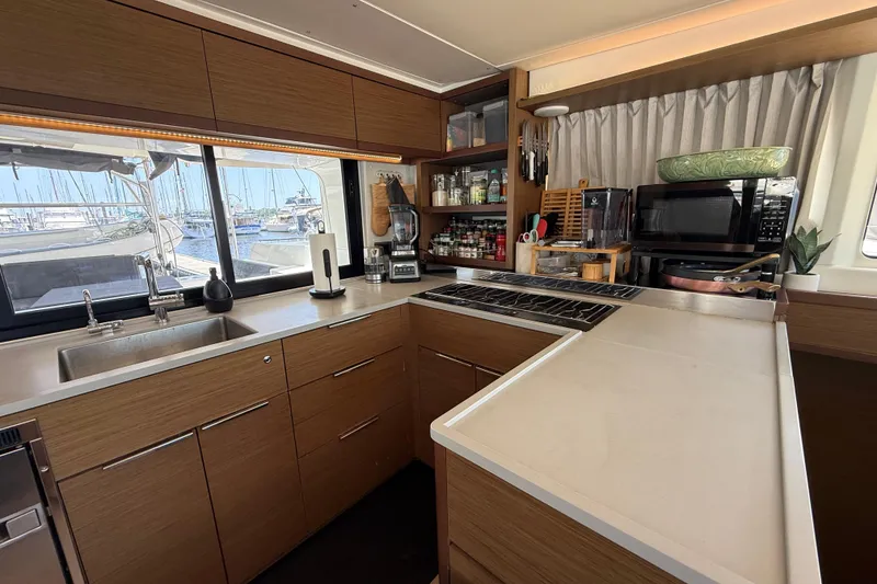 Slide: The Image of Modern kitchen interior on a 2021 Lagoon 46 yacht, featuring sleek cabinetry and appliances. - 47