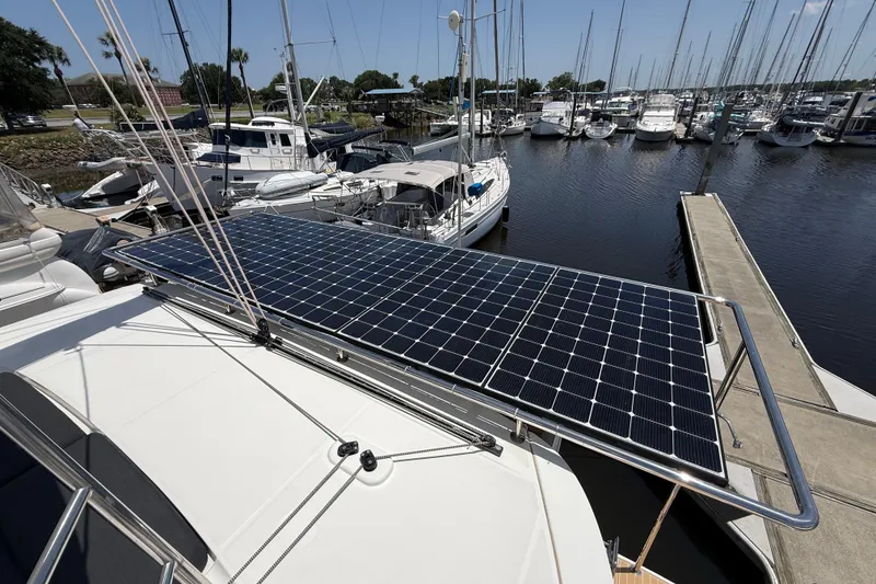 Slide: The Image of 2021 Lagoon 46 catamaran with solar panels docked at a marina. - 20
