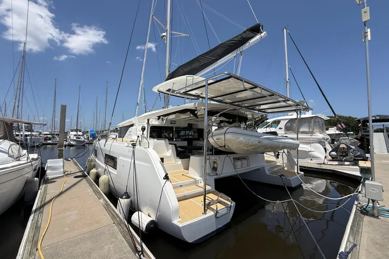 Slide: The Image of 2021 Lagoon 46 catamaran docked at marina under clear blue sky. - 10