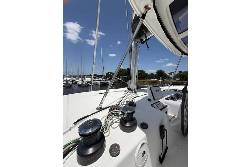 Slide: The Image of Lagoon 46 catamaran deck view, 2021 model, docked at marina under clear blue sky. - 22