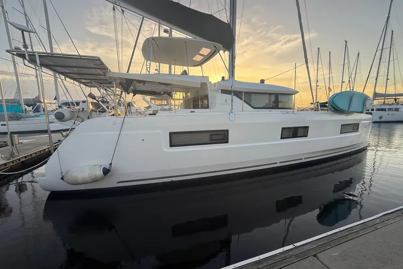 Slide: The Image of 2021 Lagoon 46 catamaran docked at sunset, showcasing sleek design and modern features. - 8