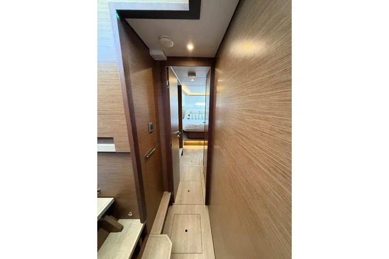 Slide: The Image of Interior hallway of 2021 Lagoon 46 yacht, featuring sleek wood paneling and modern design. - 81