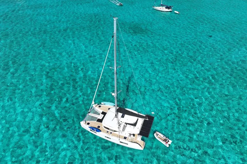 Slide: The Image of Aerial view of 2021 Lagoon 46 catamaran on clear turquoise water. - 6