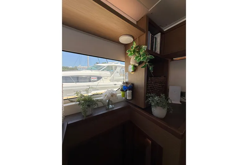 Slide: The Image of Interior of 2021 Lagoon 46 yacht with plants and books by a window. - 46