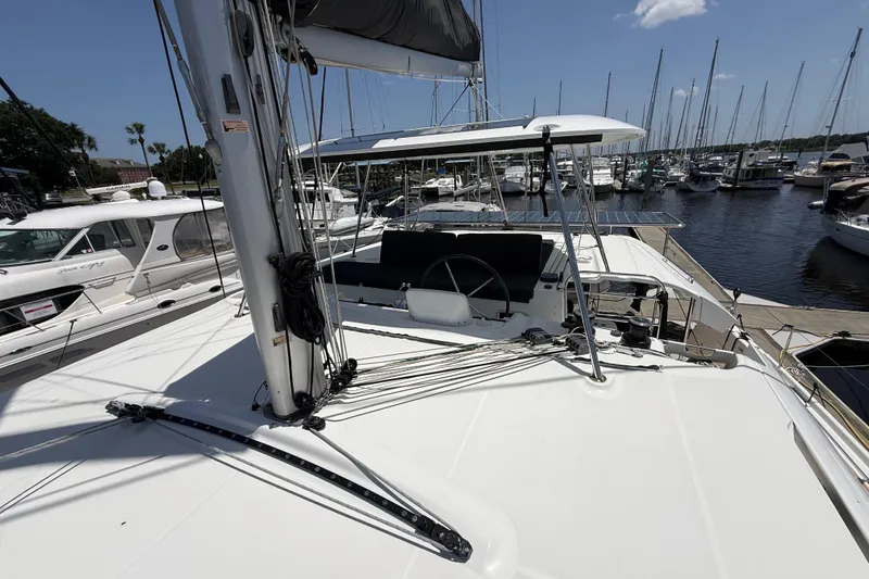 Slide: The Image of 2021 Lagoon 46 catamaran docked at marina, showcasing helm and rigging. - 24