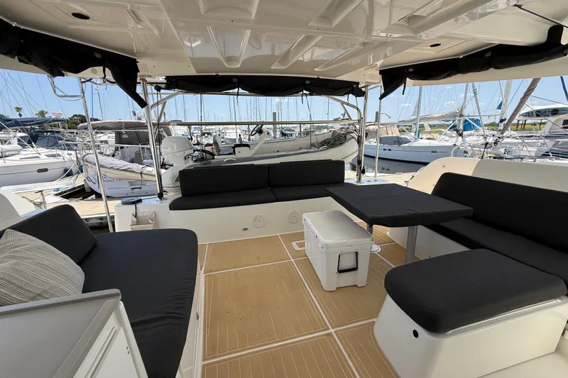 Slide: The Image of Spacious deck of 2021 Lagoon 46 catamaran with comfortable seating and marina view. - 29