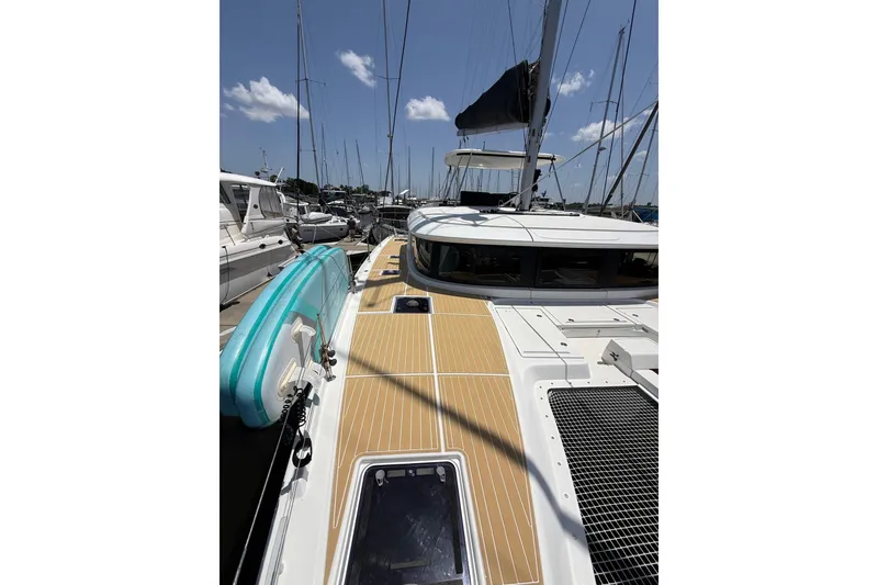Slide: The Image of 2021 Lagoon 46 catamaran docked, featuring a spacious deck and paddleboard. - 26