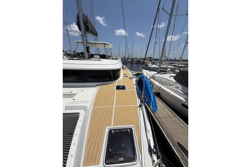 Slide: The Image of 2021 Lagoon 46 catamaran docked at marina, showcasing sleek deck design and modern features. - 27