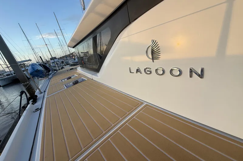 Slide: The Image of Lagoon 46 catamaran, 2021 model, docked at marina with clear sky background. - 9