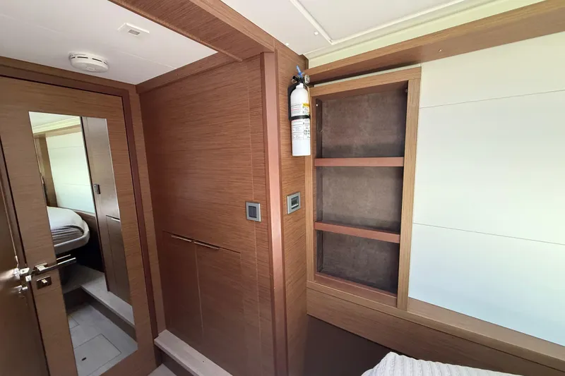 Slide: The Image of Interior of 2021 Lagoon 46 yacht with wooden cabinetry and fire extinguisher. - 62