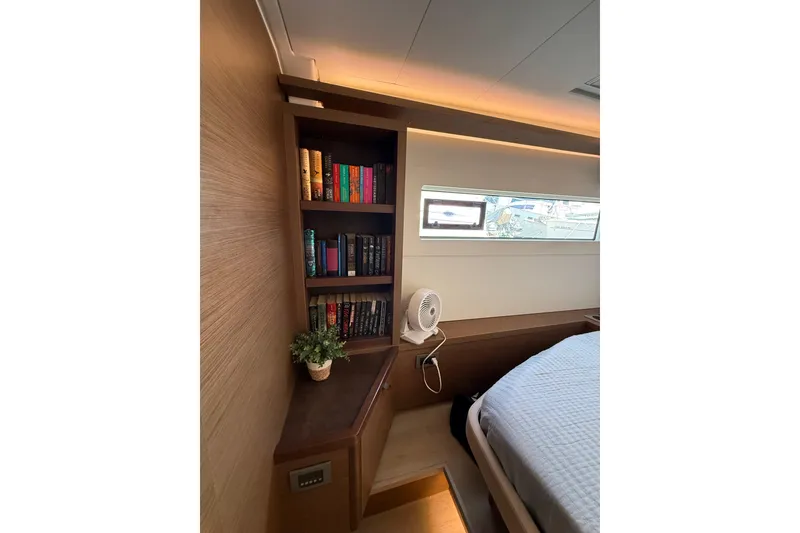 Slide: The Image of Cozy cabin interior of 2021 Lagoon 46 yacht with bookshelf and window view. - 73
