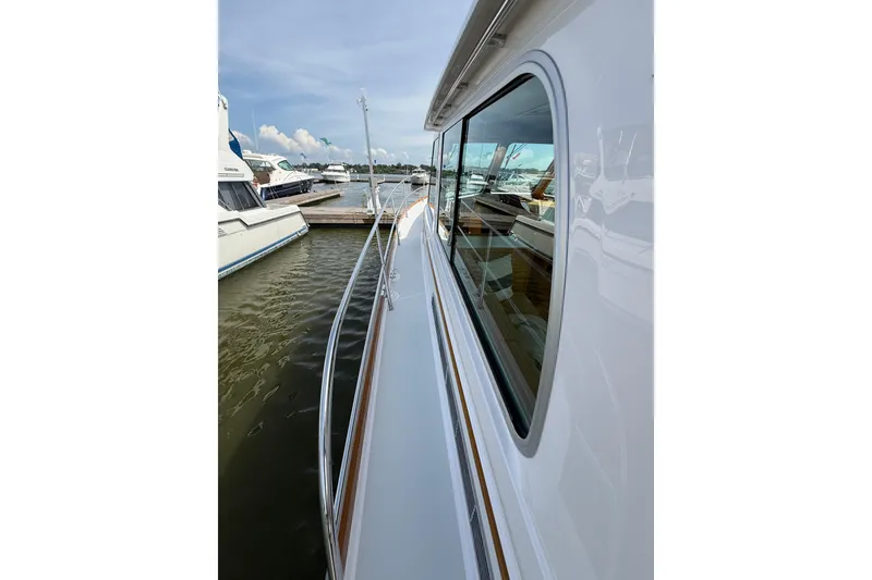 Slide: The Image of 2013 Sabre 42 Salon Express yacht docked, showcasing sleek side view and reflective windows. - 27
