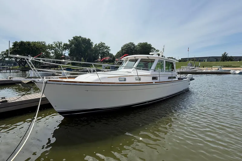 Slide: The Image of 2013 Sabre 42 Salon Express yacht docked in a marina under clear skies. - 2