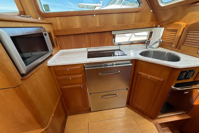 Slide: The Image of 2013 Sabre 42 Salon Express kitchen with wood cabinetry, stainless appliances, and marble countertops. - 54