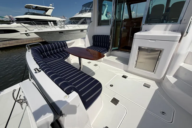 Slide: The Image of 2013 Sabre 42 Salon Express yacht with striped seating and wooden table on deck. - 16