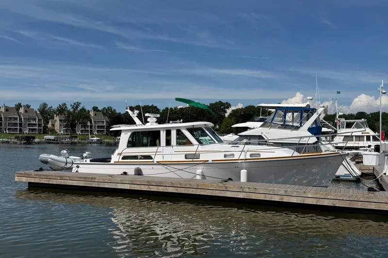 Slide: The Image of 2013 Sabre 42 Salon Express yacht docked at a marina under a clear blue sky. - 6