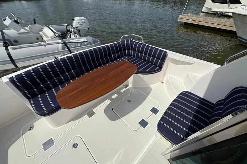 Slide: The Image of 2013 Sabre 42 Salon Express yacht with striped seating and wooden table on deck. - 14