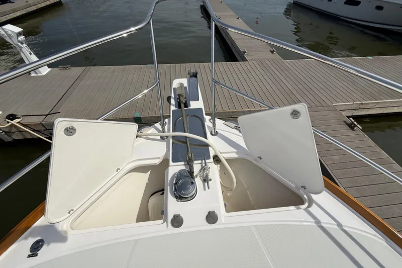 Slide: The Image of Bow view of 2013 Sabre 42 Salon Express at dock, showcasing open storage compartments. - 26