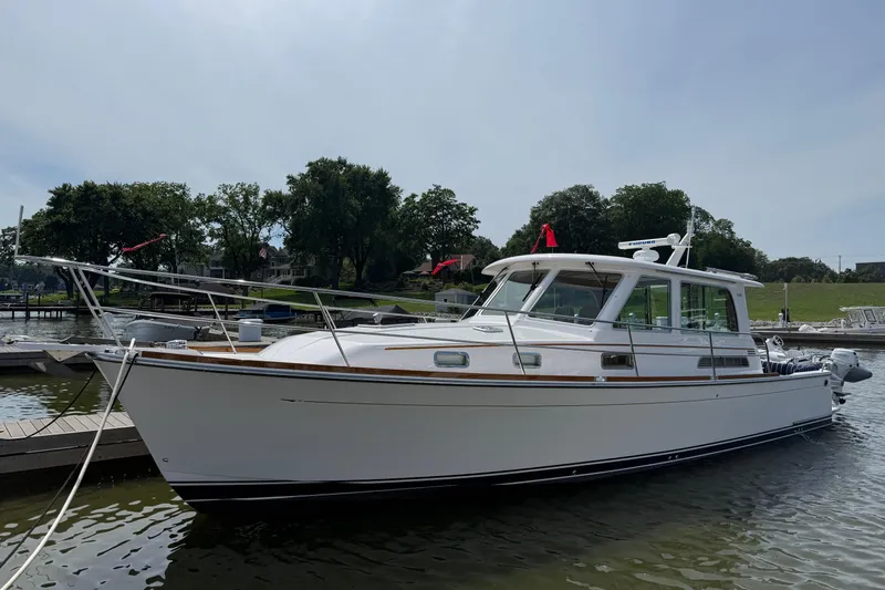 Slide: The Image of 2013 Sabre 42 Salon Express yacht docked at a marina, surrounded by trees. - 1