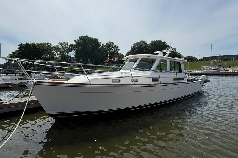 Slide: The Image of 2013 Sabre 42 Salon Express yacht docked in a marina, surrounded by calm water. - 0