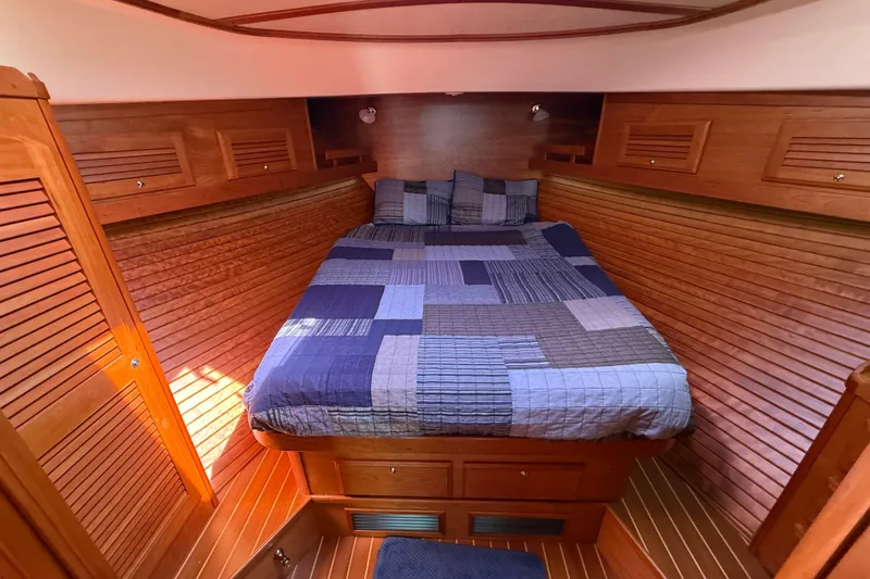 Slide: The Image of Cozy cabin interior of 2013 Sabre 42 Salon Express with wooden paneling and a patchwork quilt. - 60