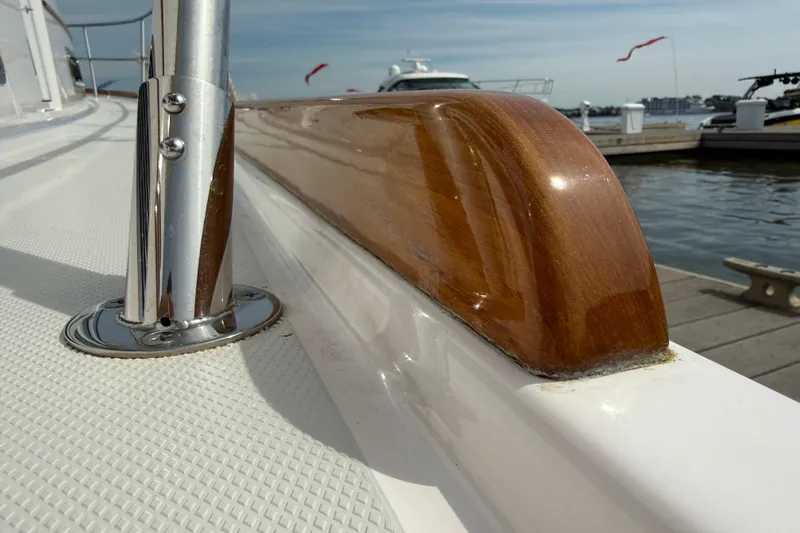 Slide: The Image of Polished wood and metal railing on 2013 Sabre 42 Salon Express yacht, docked by the water. - 82