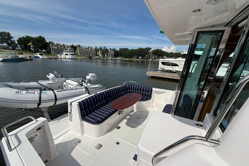 Slide: The Image of 2013 Sabre 42 Salon Express yacht with seating area, docked by the water. - 17