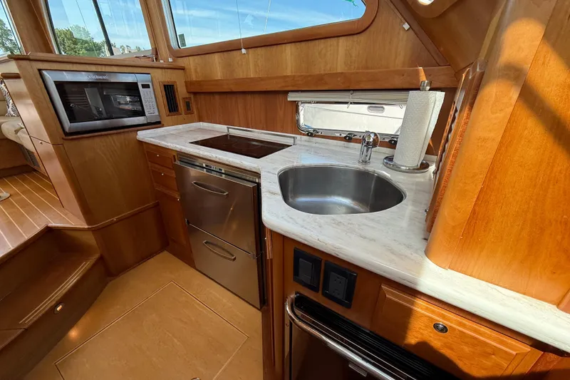 Slide: The Image of Luxurious 2013 Sabre 42 Salon Express yacht kitchen with modern appliances and elegant wood finish. - 53