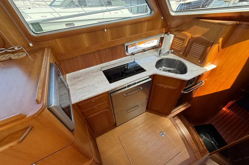 Slide: The Image of 2013 Sabre 42 Salon Express yacht kitchen with wood cabinetry and modern appliances. - 52