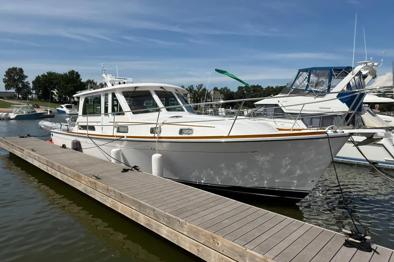 Slide: The Image of 2013 Sabre 42 Salon Express yacht docked at marina under clear blue sky. - 5