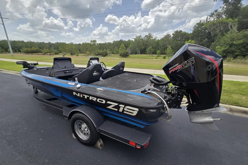 Slide: The Image of 2024 Nitro Z19 boat with Mercury Pro XS engine on a trailer, parked outdoors. - 10