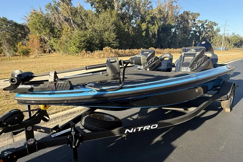 Slide: The Image of 2024 Nitro Z19 fishing boat on trailer, parked on a sunny road. - 6