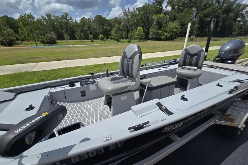 Slide: The Image of 2020 G3 Sportsman 1610 SS boat with seating, motor, and fishing equipment on a sunny day. - 2