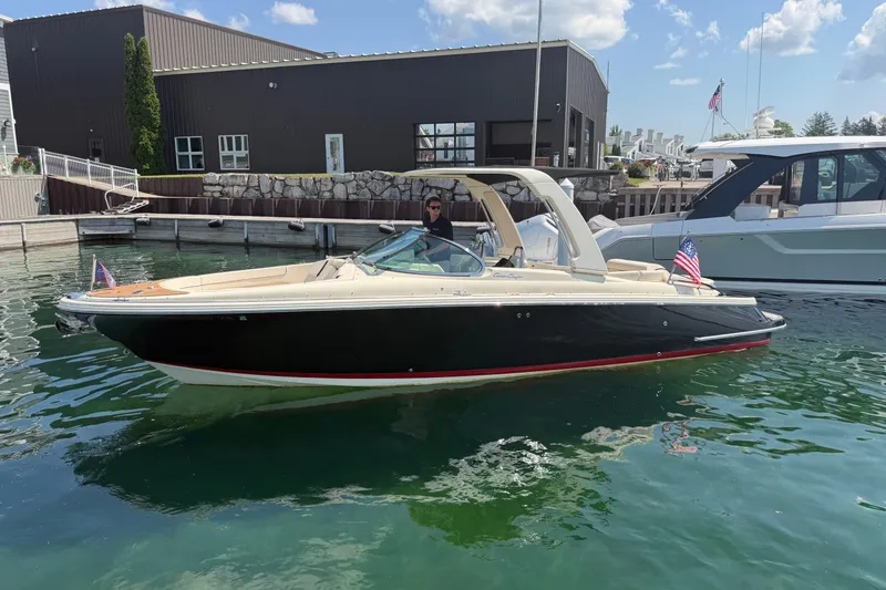 The Image of 2023 Chris-Craft Launch 28 GT boat docked in marina, featuring sleek design and American flag. - 0
